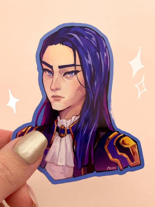Die-cut vinyl sticker of Caitlyn Kiramman from Arcane, with long dark blue hair and a sharp Piltover uniform featuring a white ruffled collar and gold trim, held between fingers against a peach background.