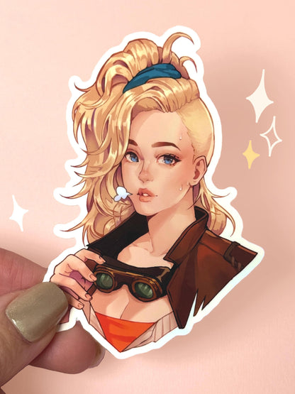Die-cut vinyl sticker of Gemma the Smithy from Monster Hunter Wilds, blonde hair tied up with a blue scrunchie, holding her steampunk-style goggles, wearing a brown leather jacket over an orange undershirt with a small comic-style sigh puff, held between fingers against a peach background.