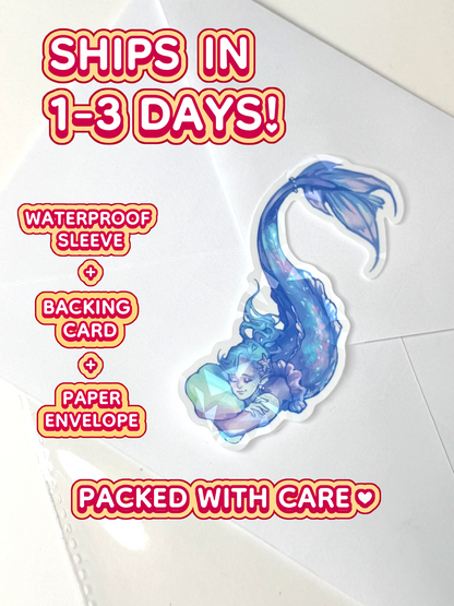 The holographic mermaid ships in 1 to 3 days in a waterproof sleeve, backing card, and paper envelope.