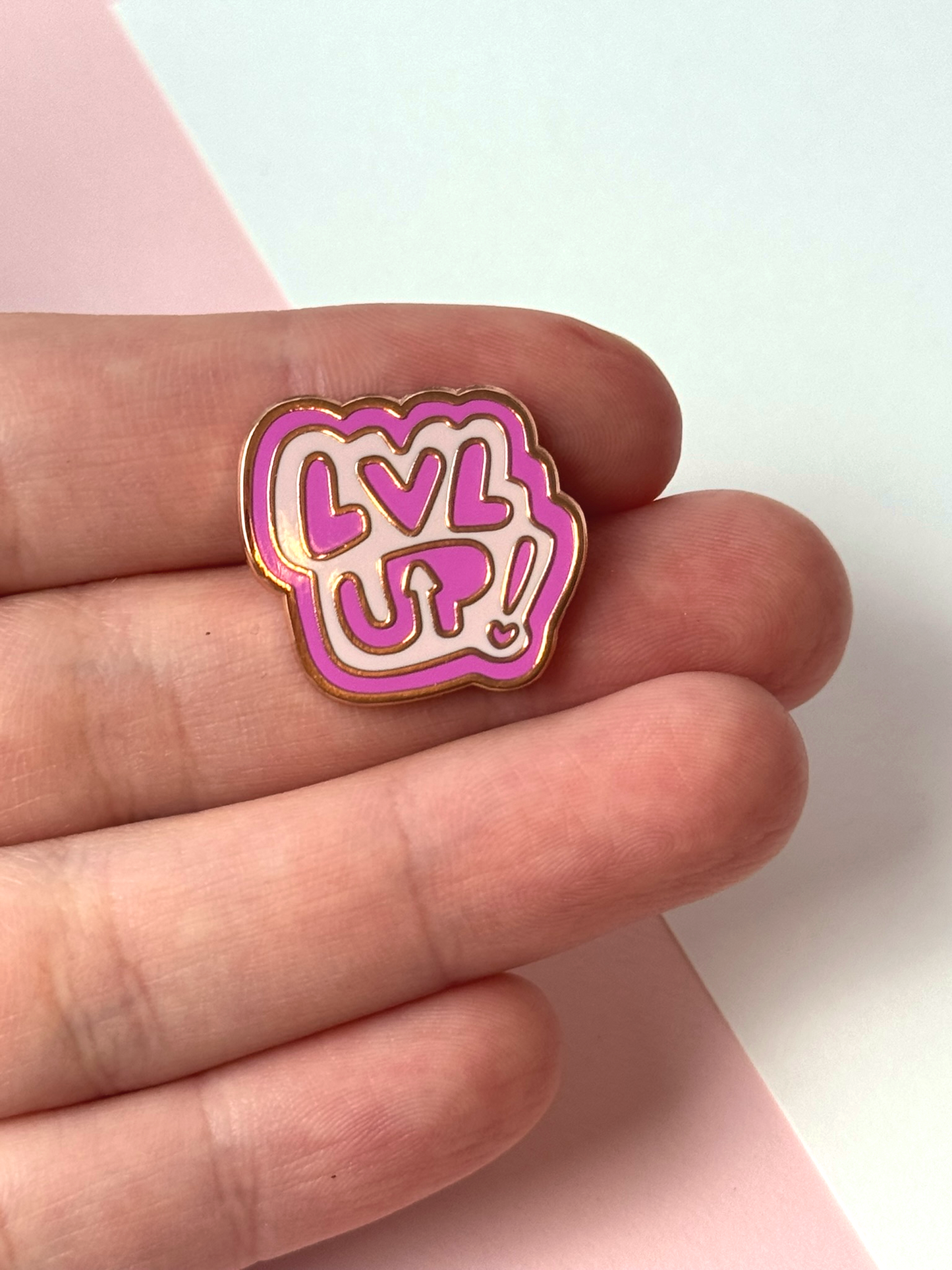 The LVL UP pin held in hand.