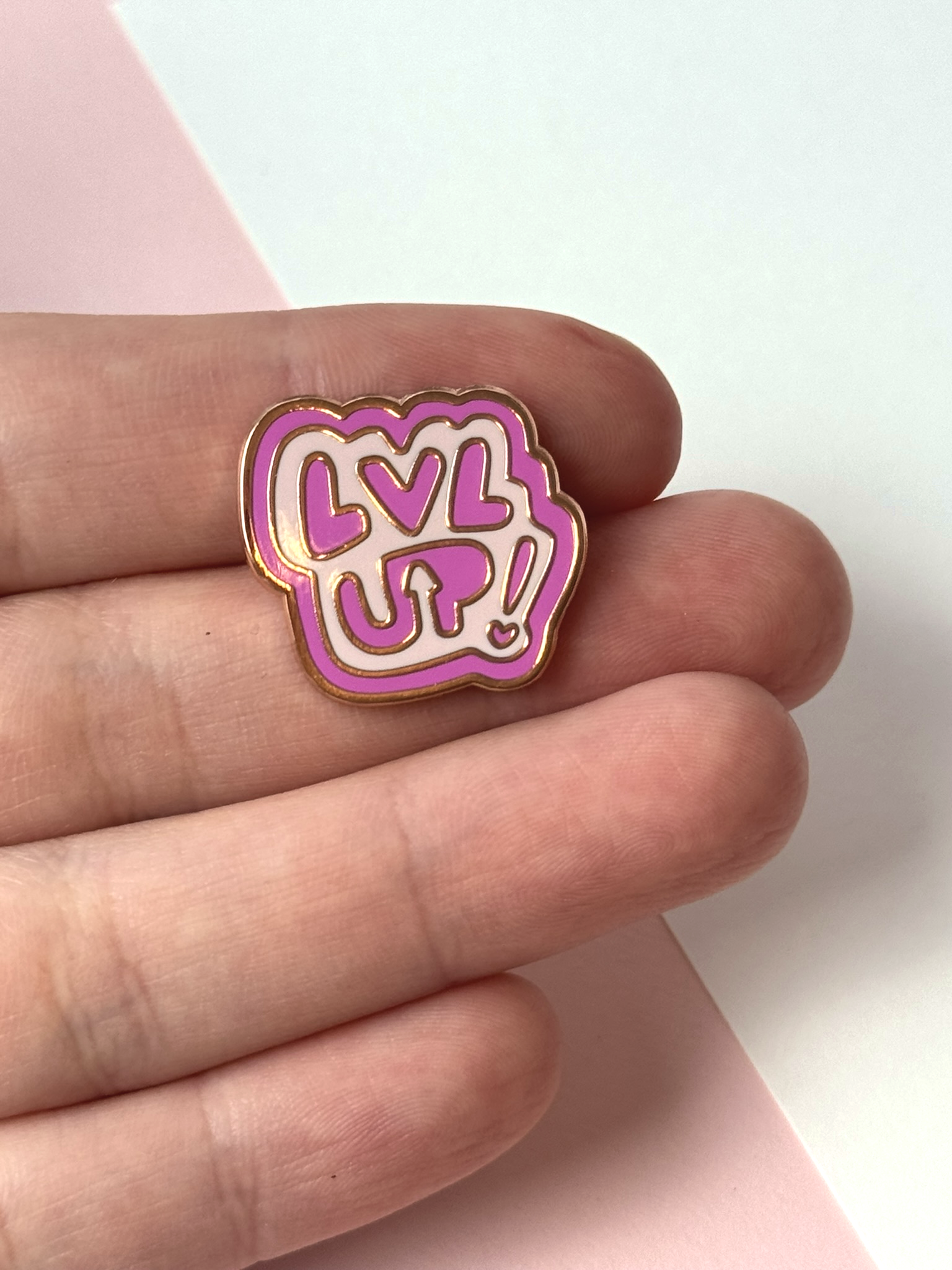 The LVL UP pin held in hand.