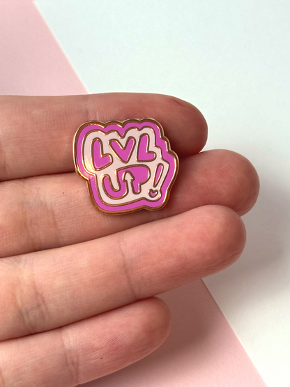 The LVL UP pin held in hand.