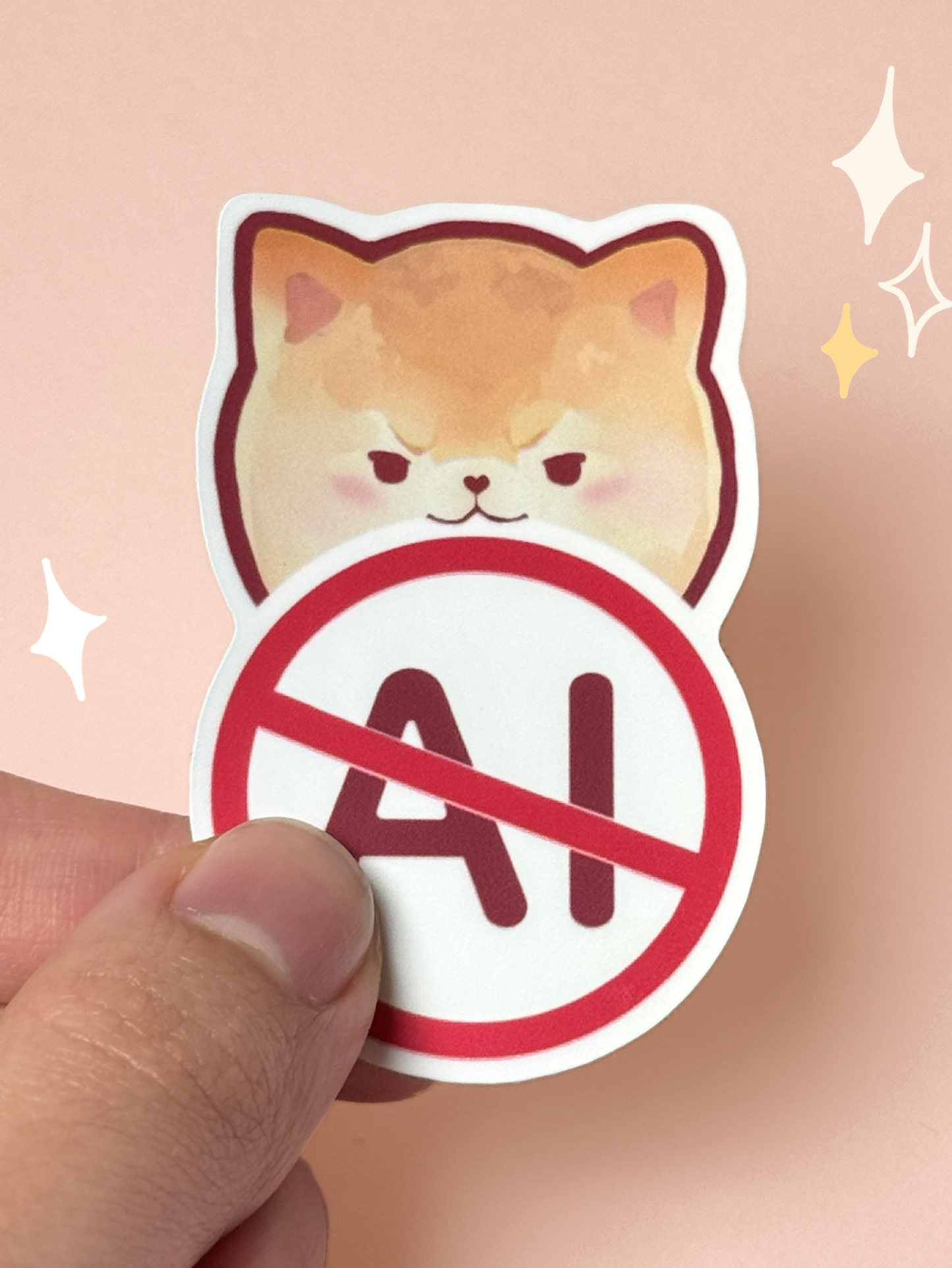 Die-cut vinyl sticker of a grumpy orange Pomeranian face above a red prohibition symbol crossing out the letters "AI", held between fingers against a peach background.