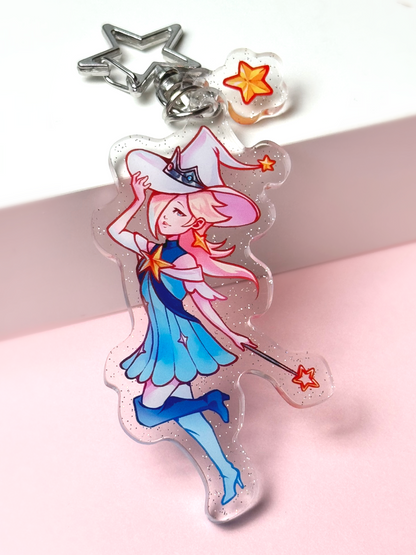 Holographic acrylic keychain of Princess Rosalina from Super Mario reimagined as a mage — pale blonde hair, a blue witch hat and dress, holding a star wand, with a star-shaped clasp and a star charm.