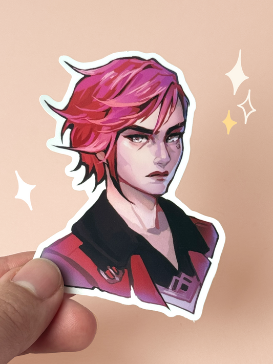 Die-cut vinyl sticker of Vi from Arcane, with messy pink hair, sharp grey eyes, dark lipstick, and her signature "VI" face tattoo, wearing a red and black collared jacket, held between fingers against a peach background.