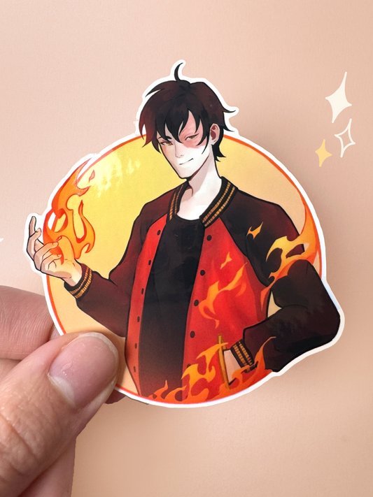 Die-cut vinyl sticker of Zuko from Avatar: The Last Airbender in a modern outfit — black varsity jacket with red and gold flame detailing, his iconic scar over his left eye, with firebending flames swirling around him in a circular yellow frame, held between fingers against a peach background.